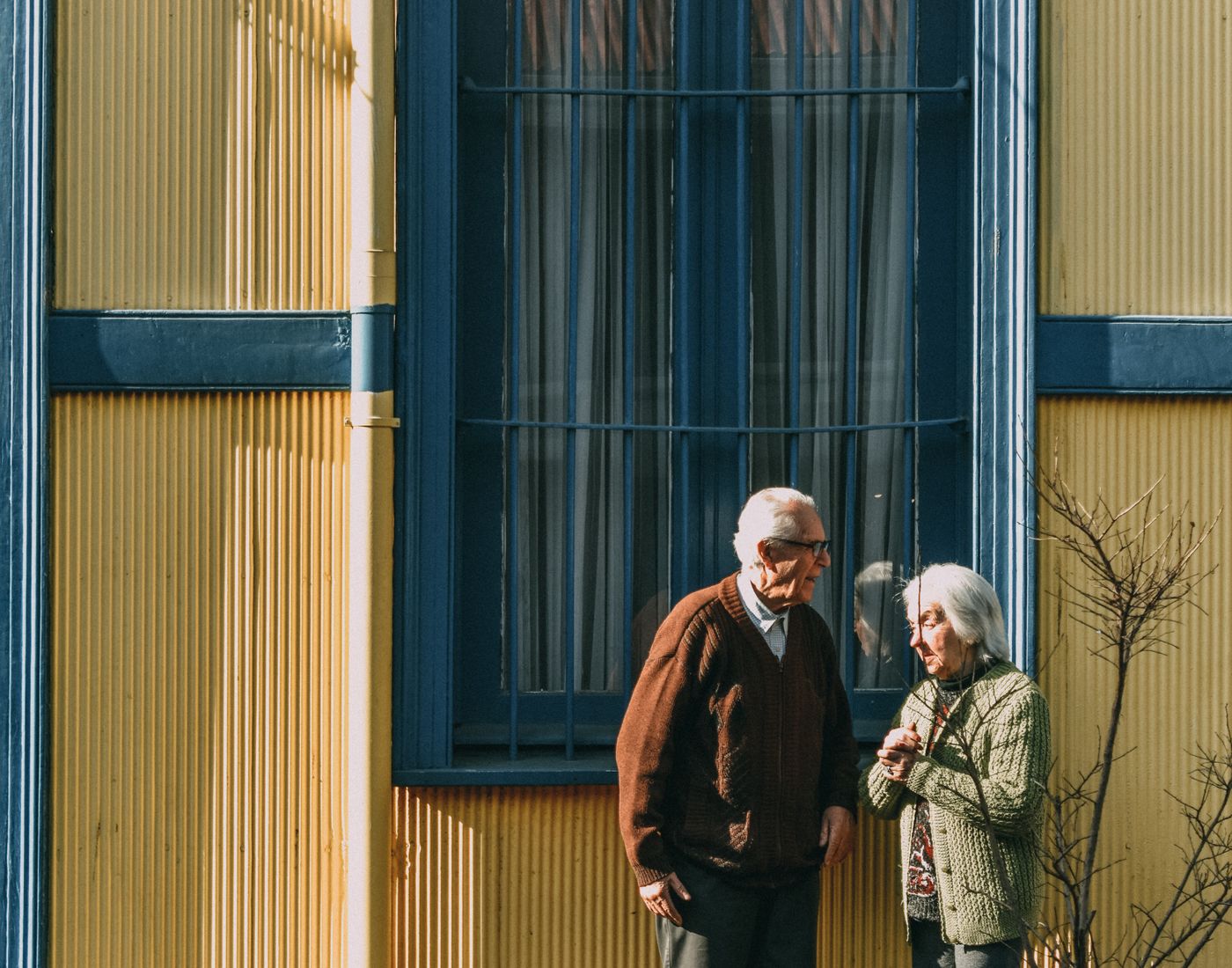 Pareja de personas mayores frente a una fachada colorida en Valparaíso, Chile